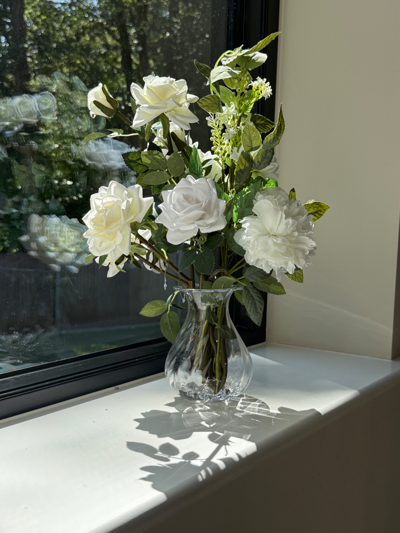 White roses on a sunlit windowsill
