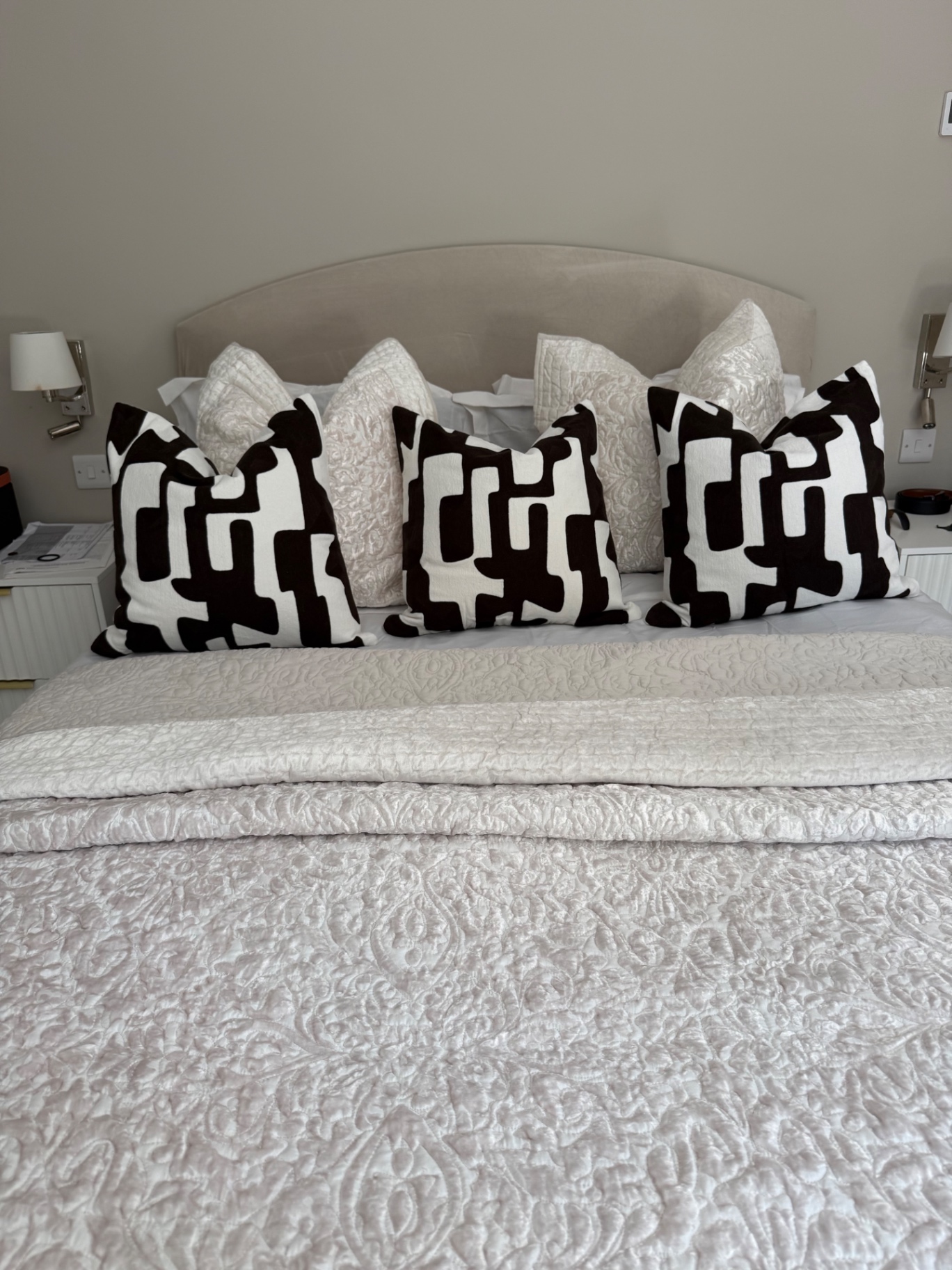 Principal bedroom with graphic monochrome cushions and quilted throws