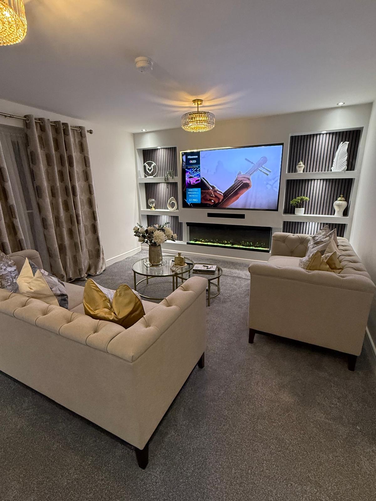Maison d’Exeter — beige tufted sofas, crystal chandelier and slatted media wall