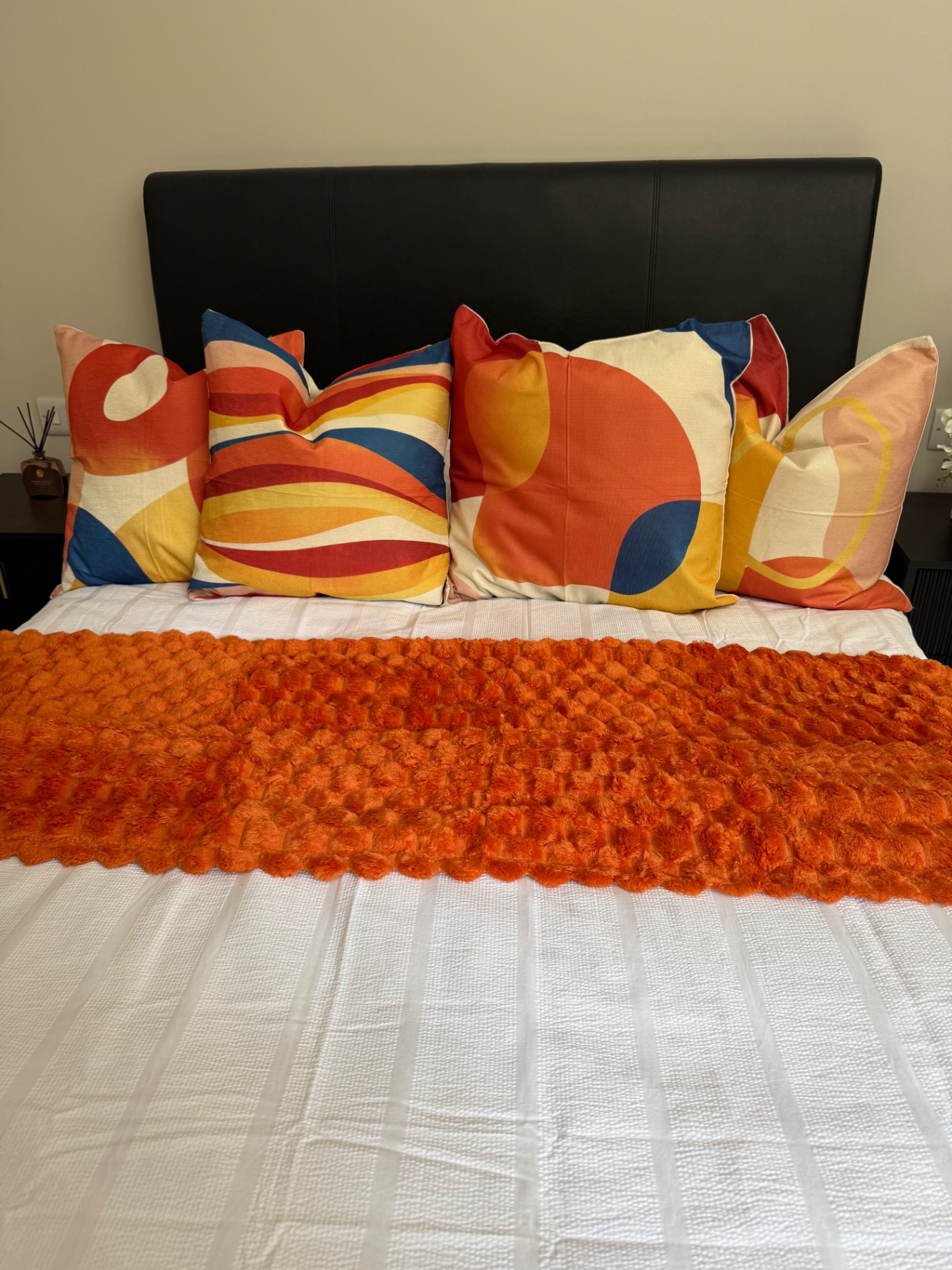 Guest bedroom layered in citrus tones and textured throw